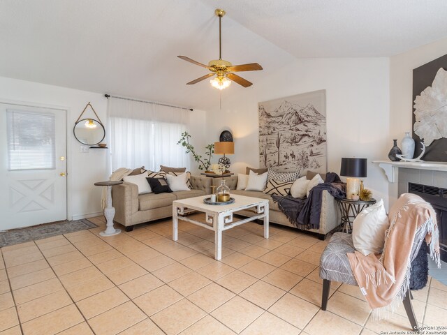 tiled living room with lofted ceiling, ceiling fan, a fireplace, and a wealth of natural light