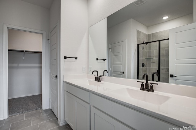 bathroom with an enclosed shower, vanity, and tile patterned flooring