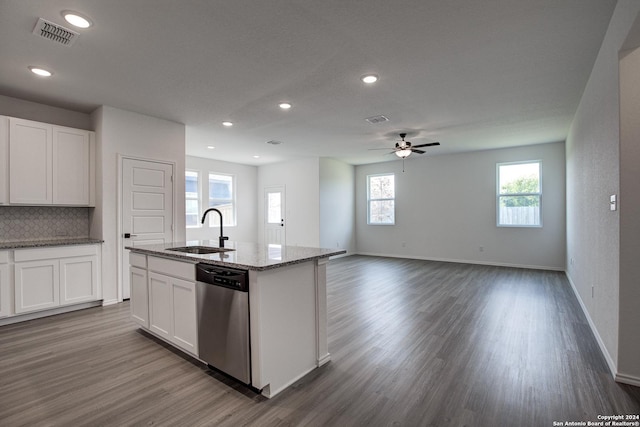 kitchen featuring an island with sink, sink, white cabinets, hardwood / wood-style flooring, and stainless steel dishwasher