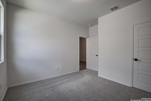 carpeted empty room with a textured ceiling