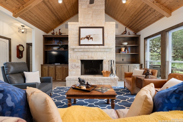 living room with a stone fireplace, beamed ceiling, wood ceiling, built in shelves, and high vaulted ceiling