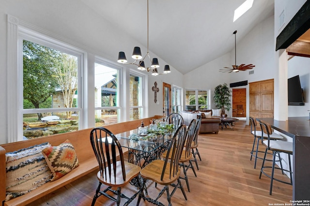 dining room with high vaulted ceiling, plenty of natural light, and light wood-type flooring