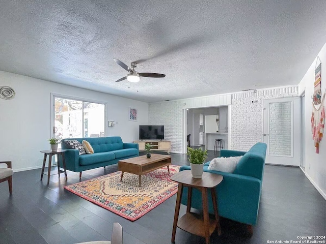 living room with ceiling fan and a textured ceiling