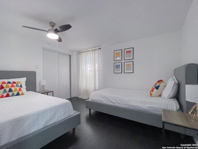 bedroom with a closet, ceiling fan, and dark hardwood / wood-style flooring