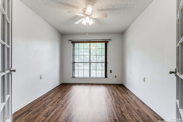 unfurnished room featuring dark hardwood / wood-style flooring, ceiling fan, and a textured ceiling