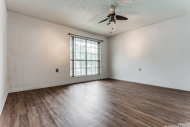 empty room featuring a textured ceiling, ceiling fan, and dark wood-type flooring