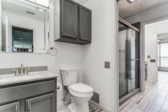 bathroom featuring a shower with door, toilet, oversized vanity, and a textured ceiling