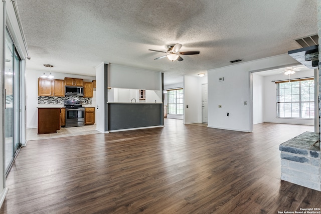 unfurnished living room featuring tile floors, ceiling fan, and a textured ceiling