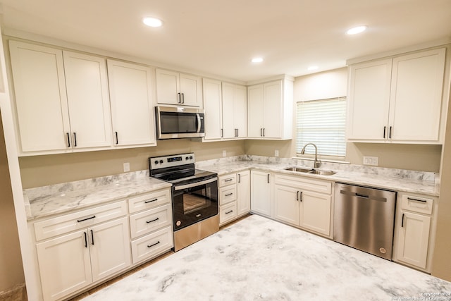 kitchen with light stone counters, sink, and stainless steel appliances