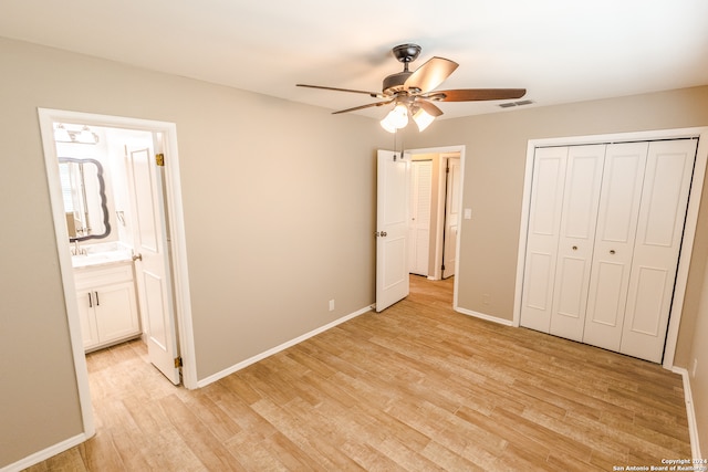 unfurnished bedroom featuring light hardwood / wood-style floors, a closet, ceiling fan, and ensuite bathroom