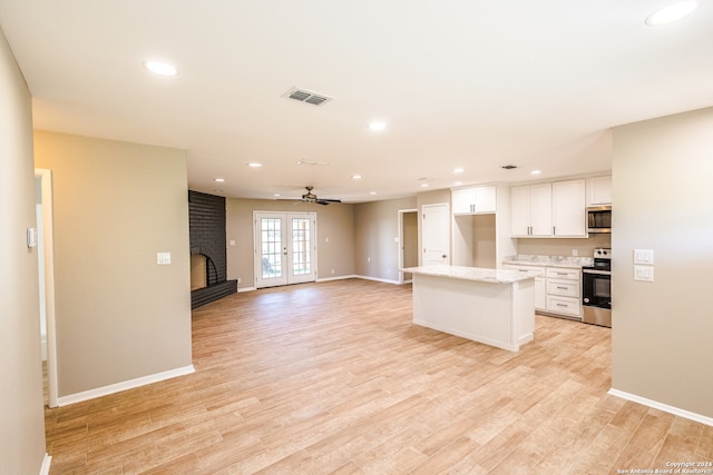 kitchen with white cabinetry, stainless steel appliances, french doors, and light wood-type flooring