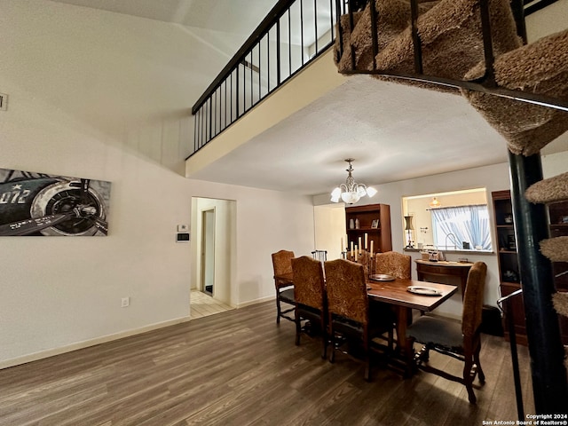 dining room with a textured ceiling, dark hardwood / wood-style flooring, and an inviting chandelier