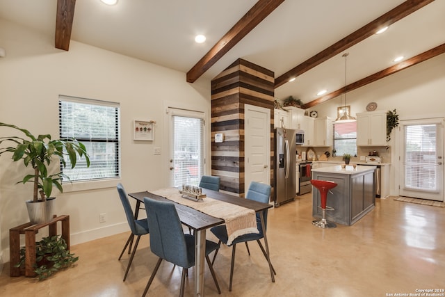 dining area featuring a wealth of natural light and vaulted ceiling with beams