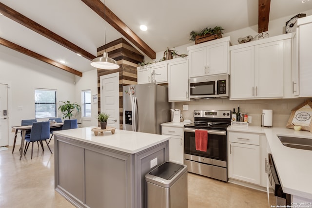 kitchen with lofted ceiling with beams, decorative light fixtures, white cabinetry, stainless steel appliances, and a kitchen island