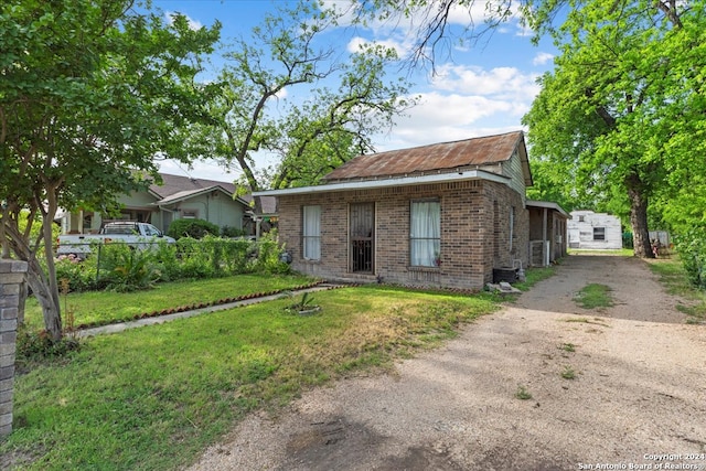 view of front of house with a front lawn and central air condition unit