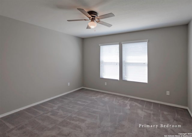 carpeted spare room with ceiling fan