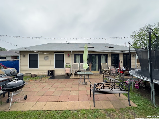 back of property featuring a trampoline and a patio