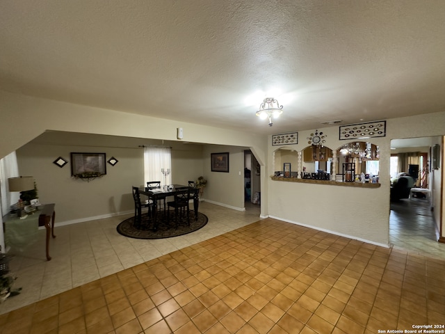 unfurnished living room with tile flooring and a textured ceiling