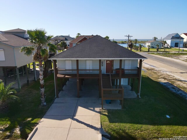 view of front of property featuring a front lawn and a carport