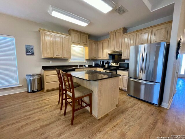 54 Pelican Prt, Oconnor, TX 77982 - kitchen with a kitchen bar, appliances with stainless steel finishes, a kitchen island, light hardwood / wood-style floors, and sink