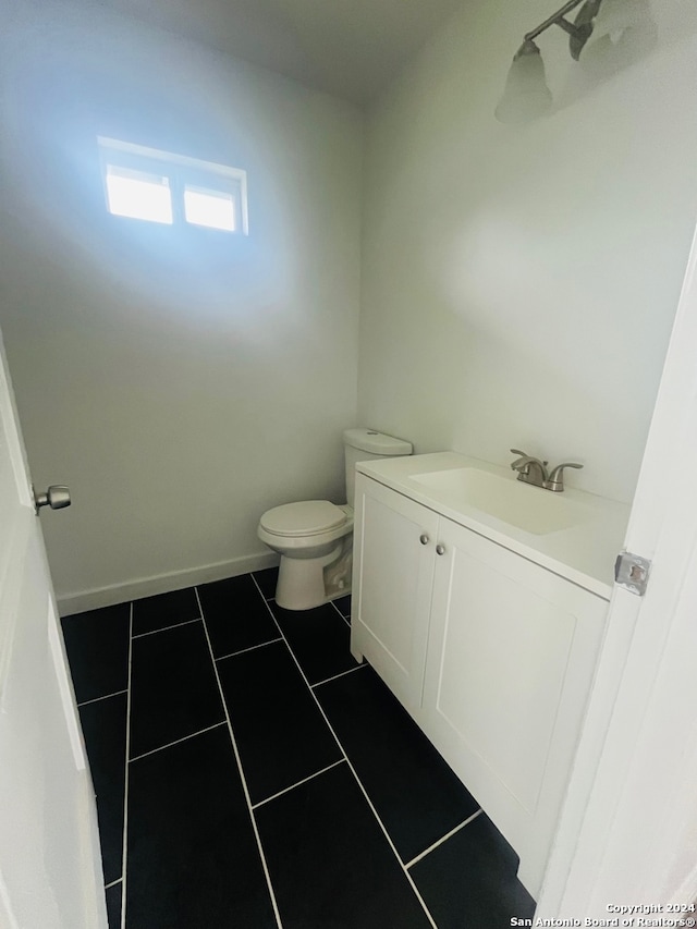 bathroom with vanity, tile floors, and toilet