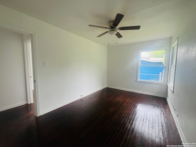 unfurnished room with ceiling fan and dark wood-type flooring