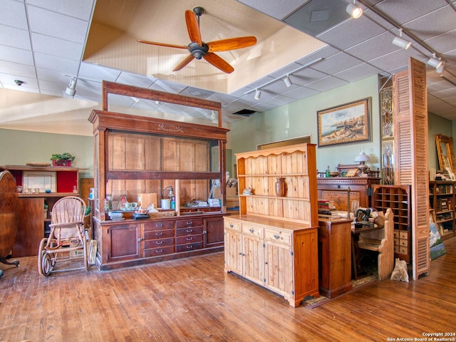 interior space with light hardwood / wood-style flooring, rail lighting, and ceiling fan