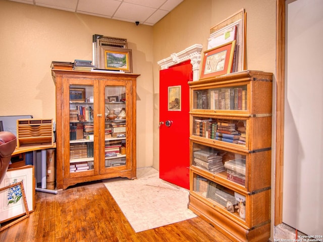 interior space with a paneled ceiling and wood-type flooring