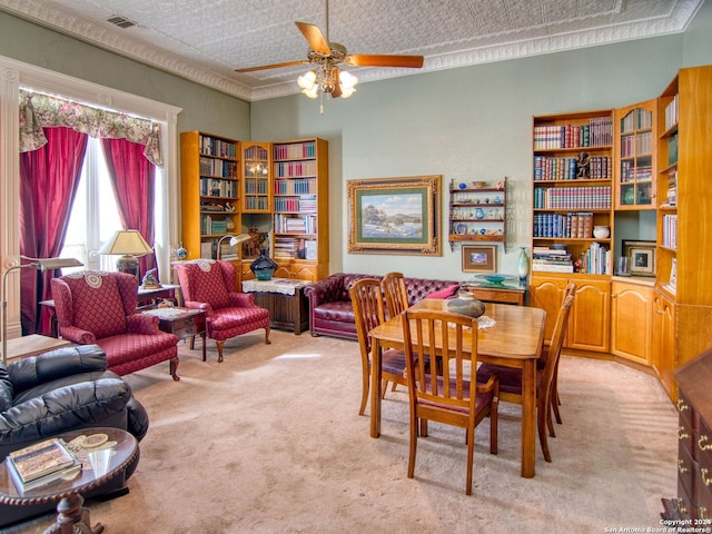 dining room with ceiling fan, light colored carpet, ornamental molding, and a textured ceiling