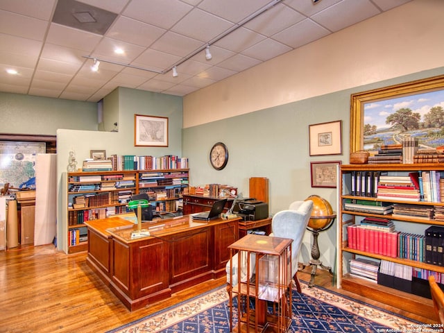 office area with track lighting, a drop ceiling, and light hardwood / wood-style floors