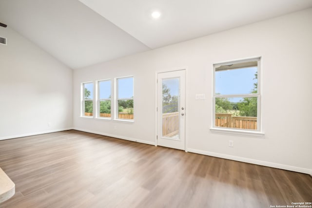 empty room with hardwood / wood-style flooring and lofted ceiling