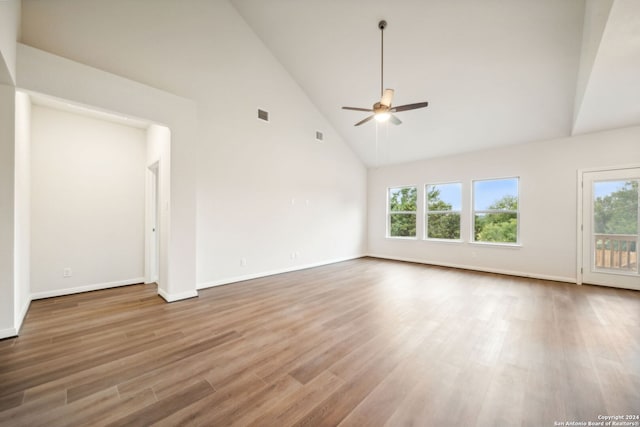 empty room featuring hardwood / wood-style flooring, ceiling fan, and high vaulted ceiling