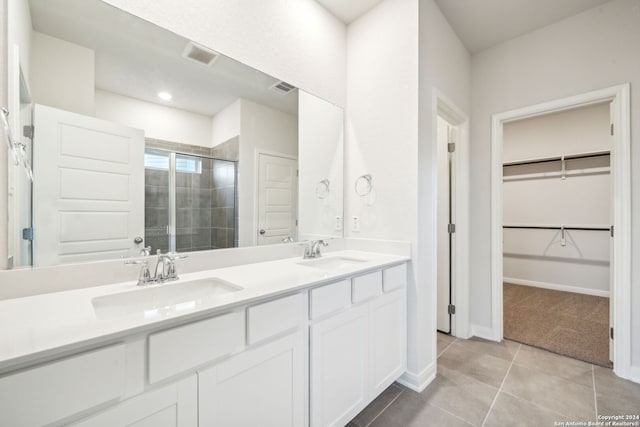 bathroom featuring tile patterned flooring, vanity, and a shower with door