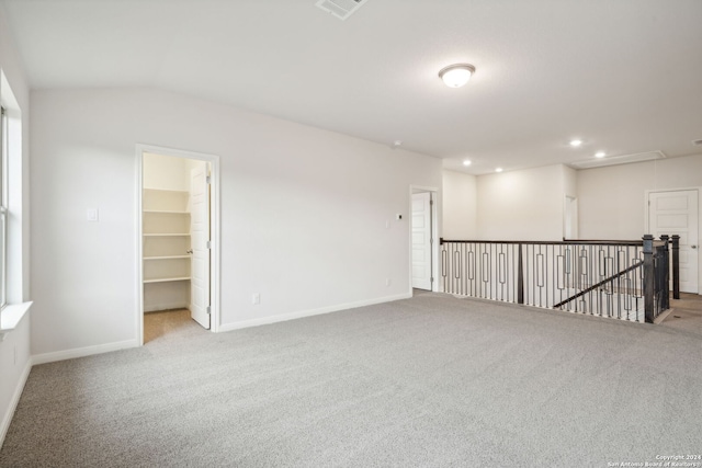 spare room with lofted ceiling and light carpet