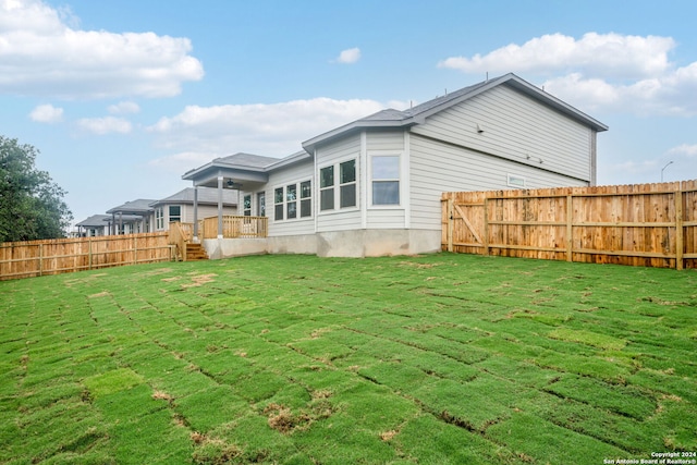 rear view of property with a lawn