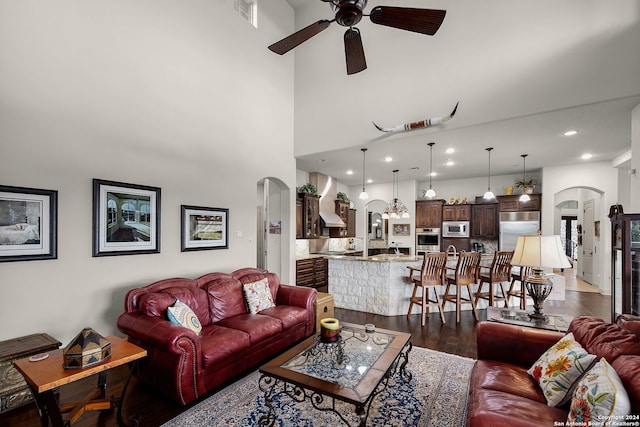 living room with sink, ceiling fan, and dark wood-type flooring