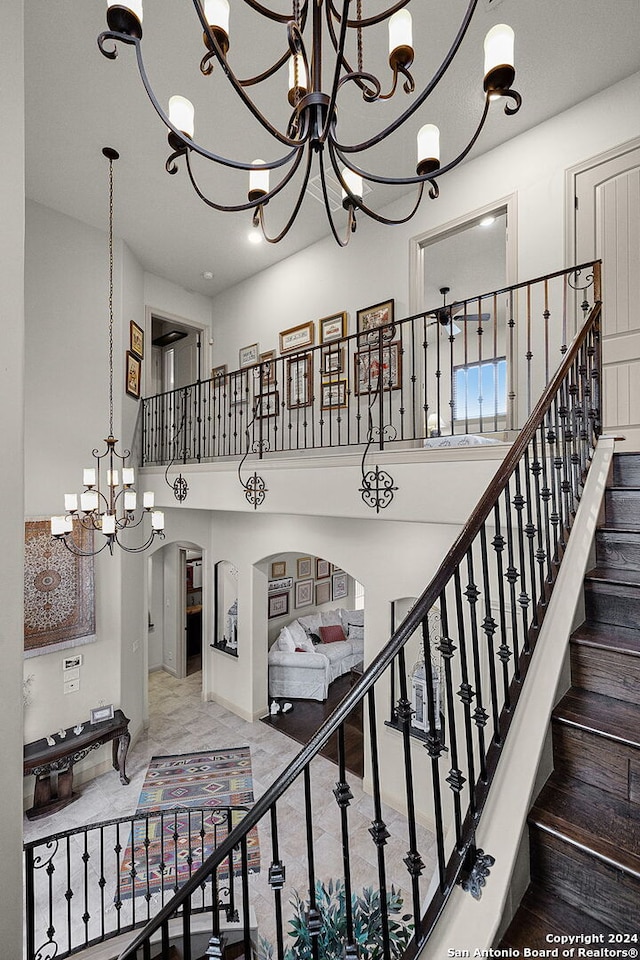 staircase featuring tile flooring and a notable chandelier