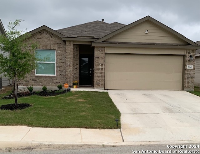 ranch-style home with a garage, driveway, a front yard, and brick siding