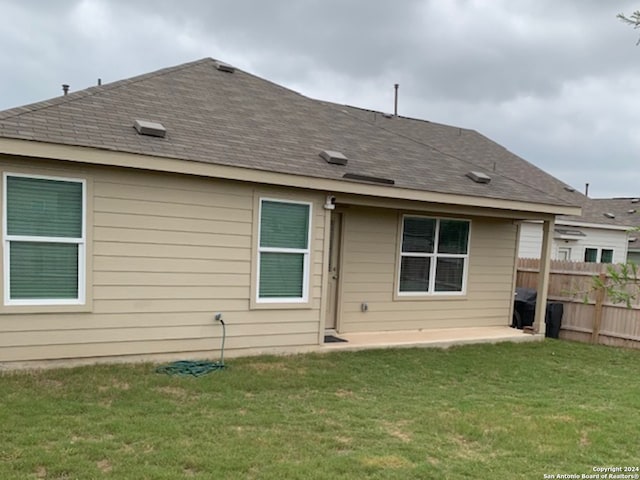 rear view of property with a lawn