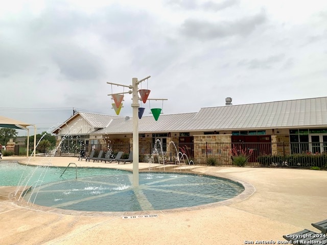 pool with a patio and fence