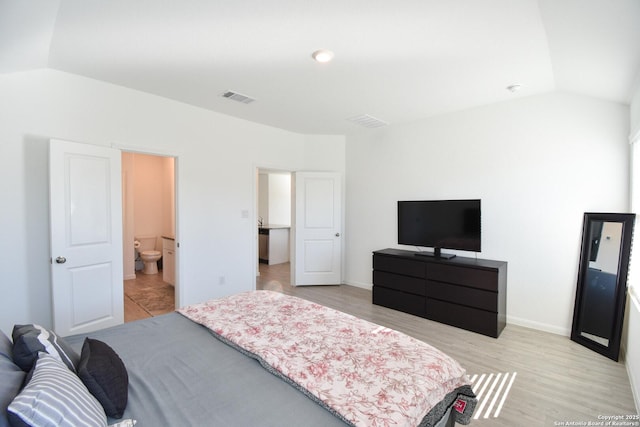 bedroom featuring vaulted ceiling, light wood-style flooring, visible vents, and baseboards