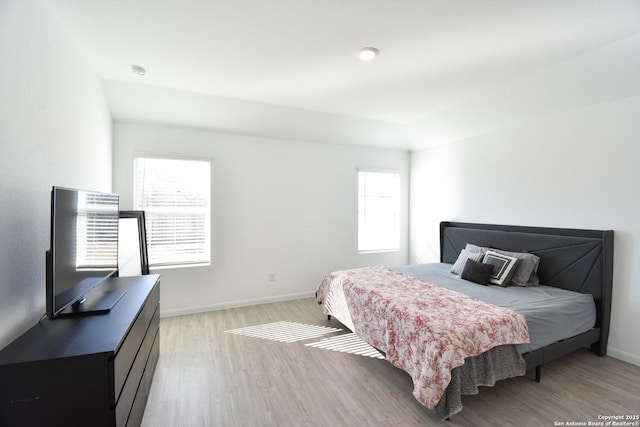 bedroom with light wood finished floors and baseboards