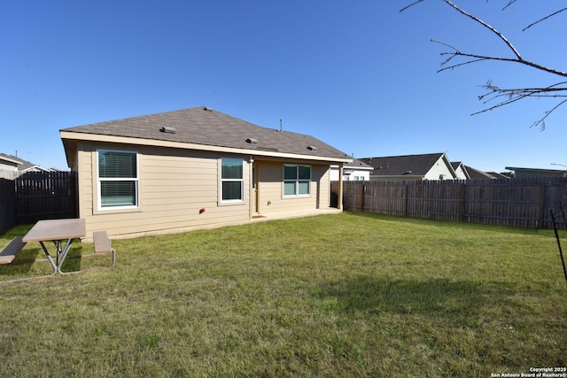 back of property with a lawn and a fenced backyard