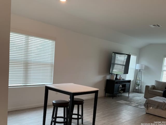 dining space featuring vaulted ceiling and light wood-type flooring