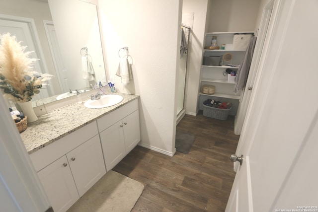 bathroom featuring walk in shower, oversized vanity, and hardwood / wood-style flooring