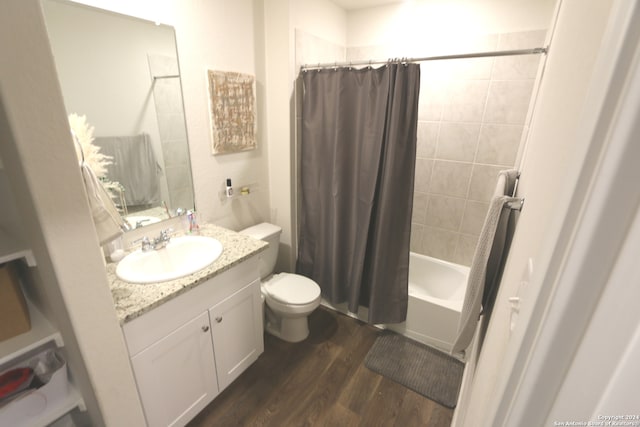 full bathroom with shower / bath combo, vanity, hardwood / wood-style flooring, and toilet