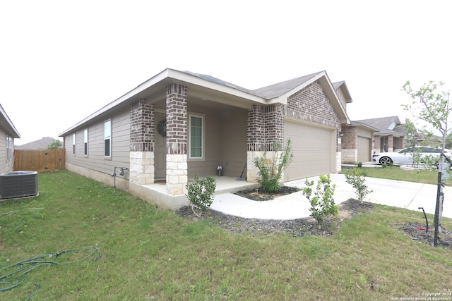 view of front of house with a front lawn, a garage, and central AC unit