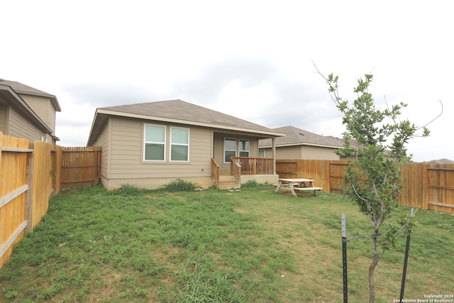 rear view of property featuring a lawn