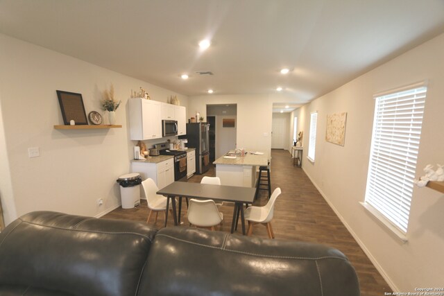 living room featuring a healthy amount of sunlight and dark hardwood / wood-style flooring