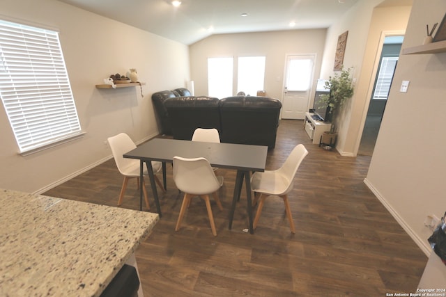 dining space with dark hardwood / wood-style flooring and vaulted ceiling